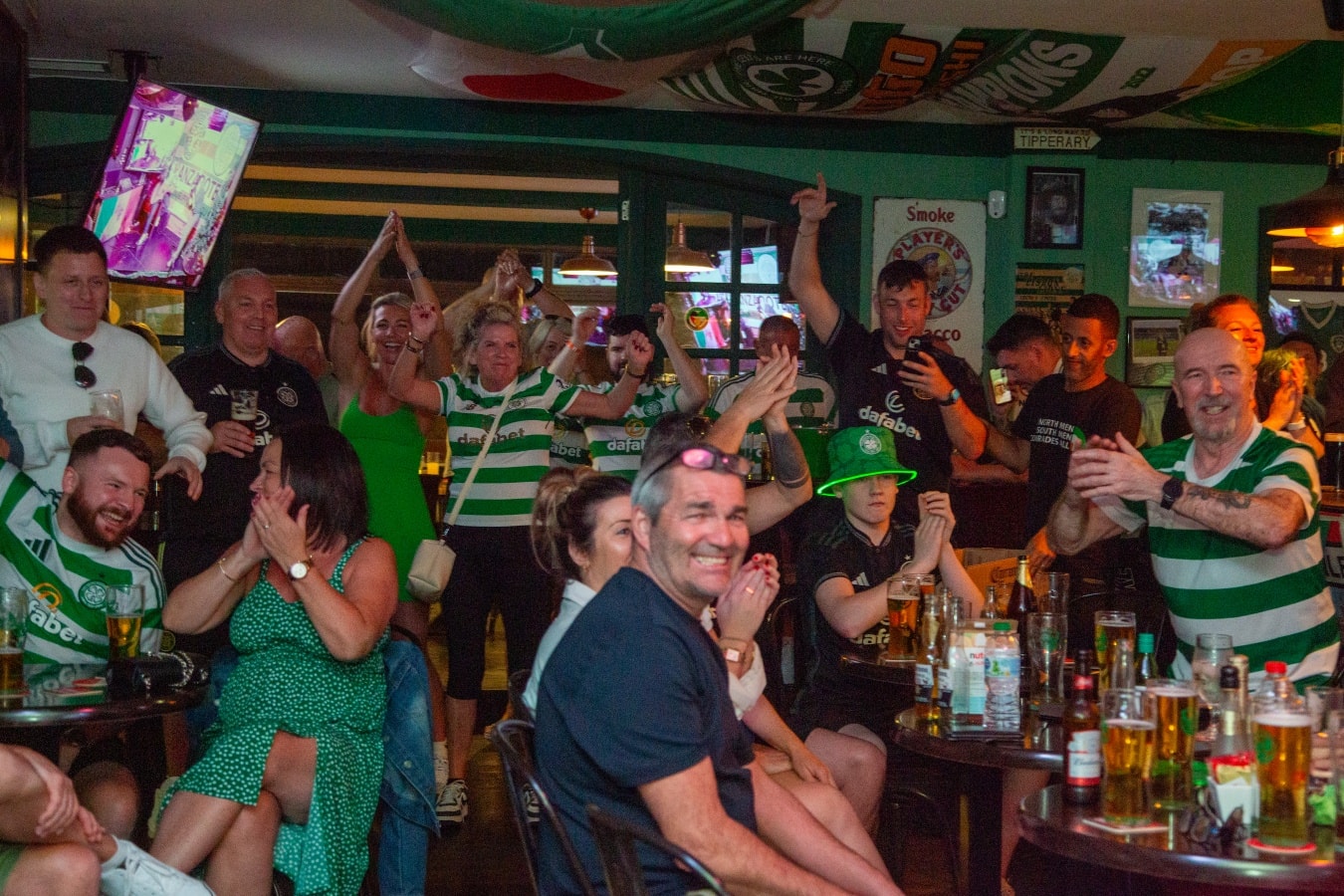 Celtic supporters cheering inside Bar 67 on match day